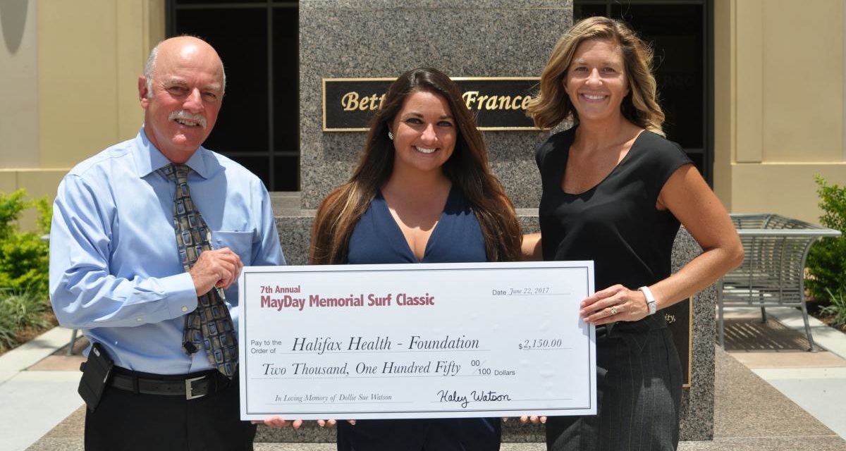 Picture of May Day Memorial Surf Classic check presentation to Joe Petrock, executive director of Halifax Health-Foundation from Haley Michelle Watson, organizer of the May Day Memorial Surf Classic and Jamie Viers, marketing specialist for Halifax Health