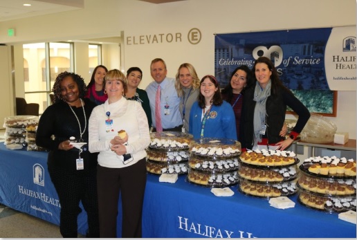 Picture of Halifax Health team members around a table with cupcakes
