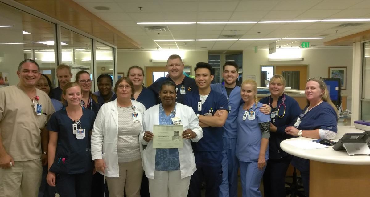 Picture of members of the Neuroscience team in Halifax Health - Comprehensive Stroke Center holding Get With The Guidelines-Stroke Gold Plus Quality Achievement Award with Target: Stroke Honor Roll Elite