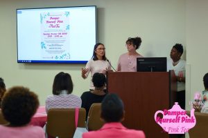Pamper Yourself Pink Seminar with three women in the front of a lecture room.